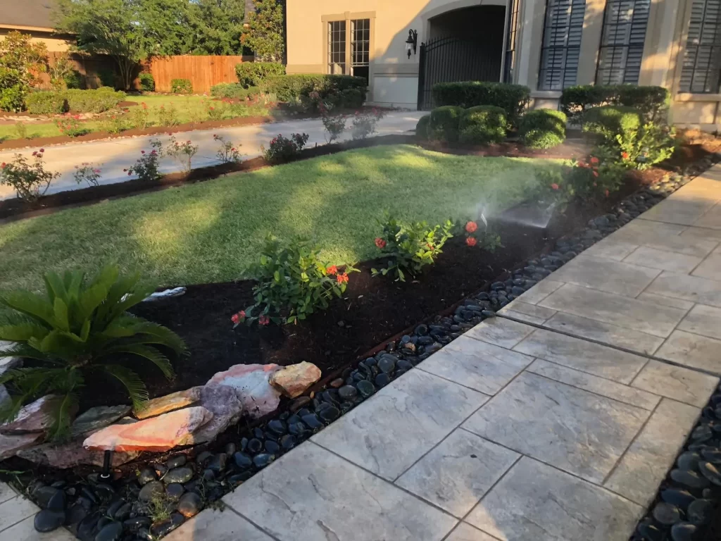 In front of a residential house installed sprinkler system in a small green lawn