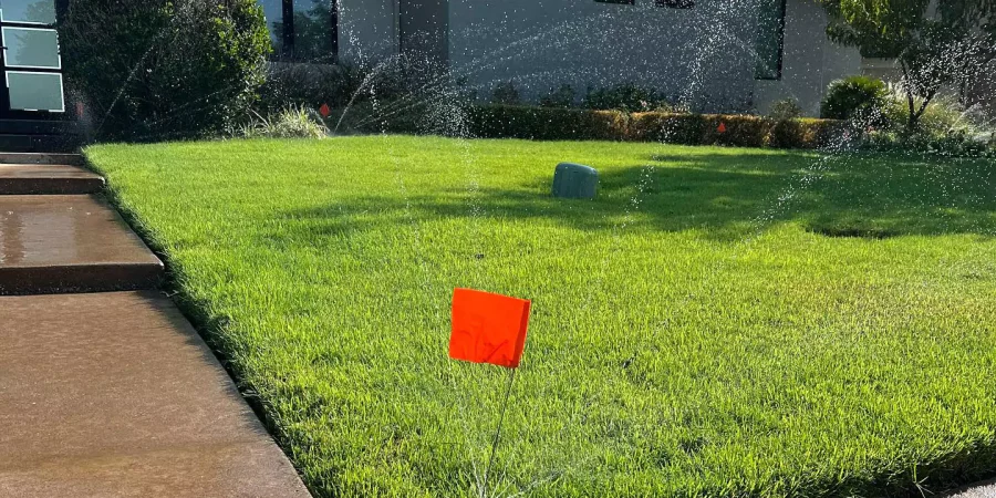 watering in a green lawn with sprinkler system
